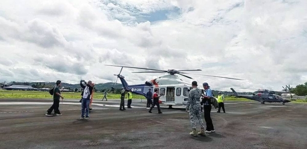 Rescuers and a helicopter prepare to resume search for Mayon volcano plane crash survivors on Tuesday. — courtesy Philippine Information Agency