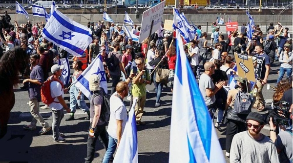 A protester waves the Israeli flag during a massive protest against the government’s judicial overhaul plan on Saturday in Tel Aviv.