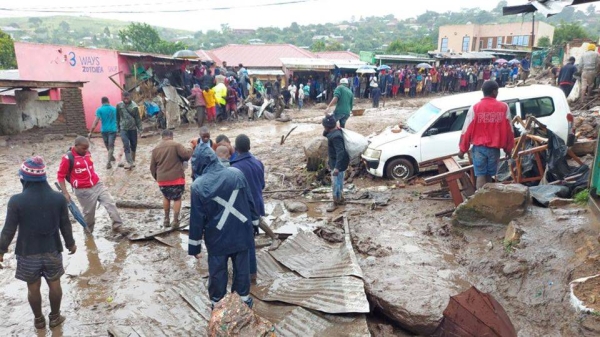 People line a muddy road in this image tweeted by Malawi Red Cross Society on March 13.