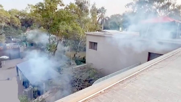 Smoke billows out of Imran Khan’s Lahore house, which was hit with tear gas.