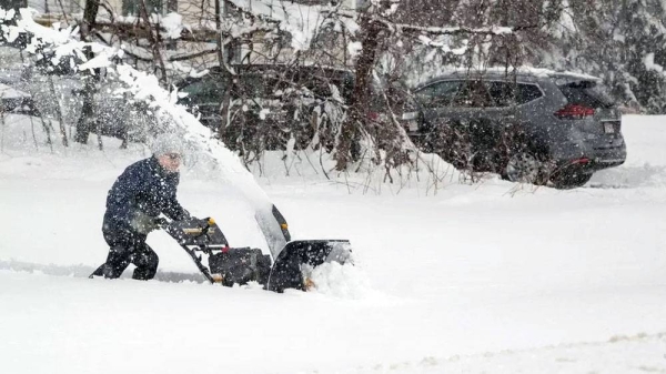 A person clears snow from his driveway. — courtesy Getty Images