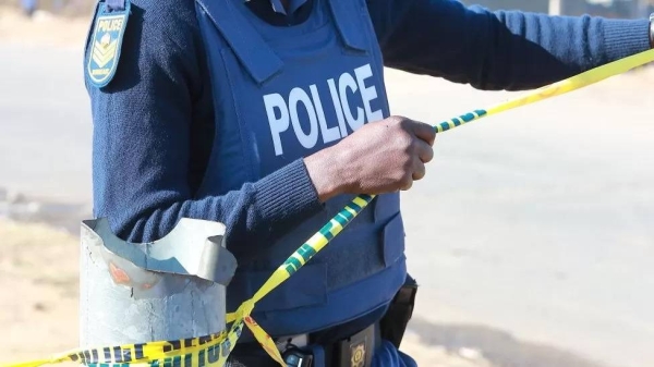 A police officer barricades a crime scene.