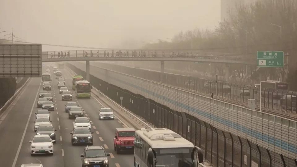 Cars drive in low-visibility through a sandstorm on March 22, 2023 in Beijing.