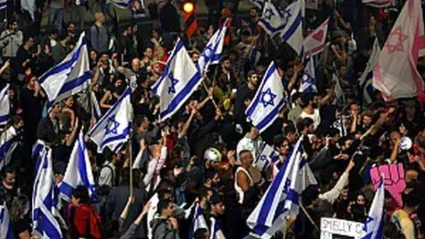 Israelis opposed to Benjamin Netanyahu's judicial overhaul plan block a highway during a protest after the leader fired his defense minister, in Tel Aviv