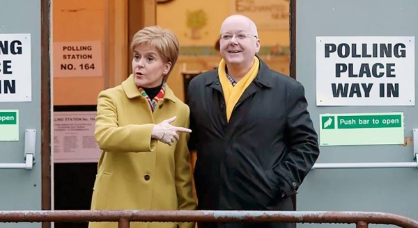 File photo shows former Scottish First Minister Nicola Sturgeon posing for the media with husband Peter Murrell, outside polling station in Glasgow, Scotland, December 2019. — courtesy AP