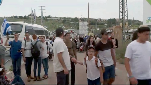 Israelis stand in outpost of Eviatar in the West Bank, Monday.