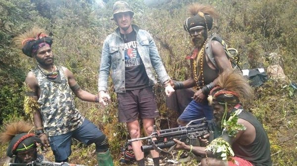 The New Zealand pilot held hostage by a pro-independence group, stands among the separatist fighters in Indonesia's Papua region, in this undated picture released by the The West Papua National Liberation Army on February 14