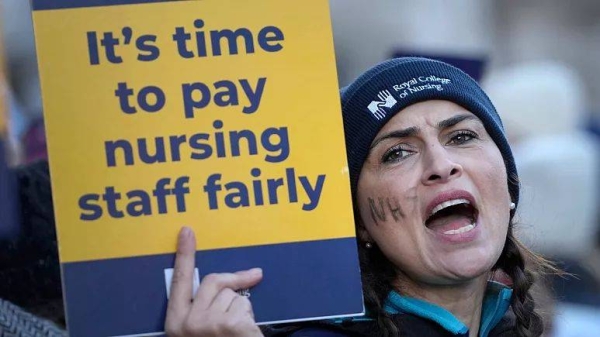 Nurses demonstrate towards passing traffic as they stand at a picket line outside the Royal Marsden Hospital in London, Thursday, Dec. 15, 2022
