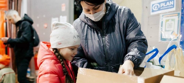 A mother and daughter from Chernihiv, Ukraine, unpack a box of new clothes, distributed by UNICEF and partners in Moldova. — courtesy UNICEF/Tapes Ion