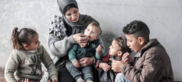 A Palestinian family in Gaza share a meal bought with a WFP food voucher. — courtesy WFP/Ali Jadallah