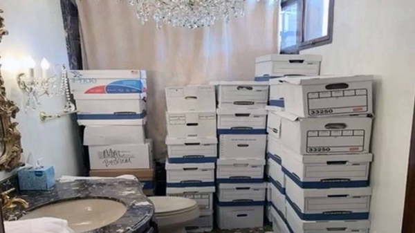 Boxes of papers are stacked in a bathroom with a chandelier and a toilet visible, at Mar-a-Lago. — courtesy DoJ
