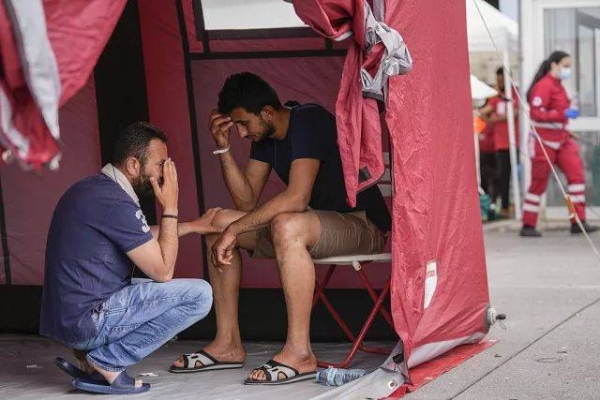 Survivors of a shipwreck react outside a warehouse at the port in Kalamata town, about 240 kilometres, southwest of Athens, on Thursday, June 15, 2023