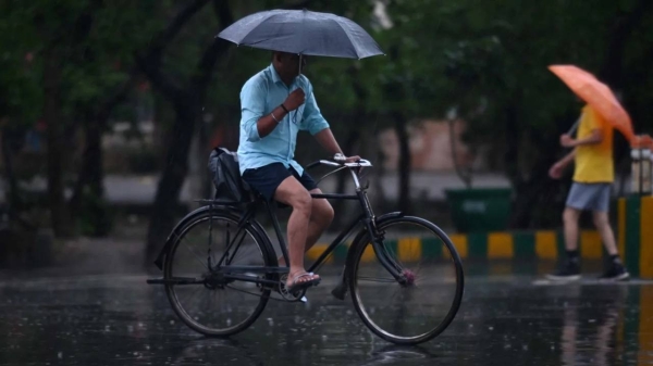 Commuters out in the light rain on the Sector 21 road, on June 25, 2023 in Noida, India.