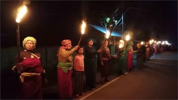 Women participating in a night protest with flaming torches, demanding peace in Manipur