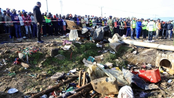 Residents gather Saturday at the scene of an accident where a lorry carrying a shipping container veered off the road and plowed into several vehicles at an open market in Londiani, western Kenya.