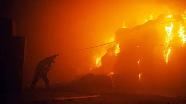 A firefighter puts out fire as a result of falling debris after a drone attack.