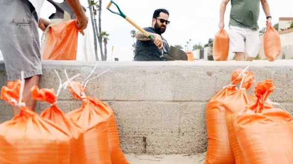 Residents of Seal Beach, California, filling up sand bags to help fortify their homes on Saturday. — courtesy EPA
