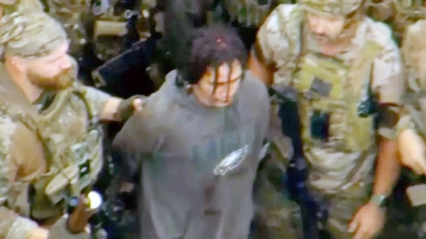 Local media footage shows a handcuffed Danelo Cavalcante, in a dirty Philadelphia Eagles sweatshirt, being escorted to an armored black police van.