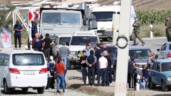 People, including Armenian service members and refugees from Nagorno-Karabakh region, gather at a checkpoint in the village of Kornidzor, Armenia. — courtesy Reuters