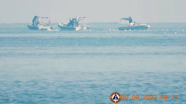 Chinese coast guard boats close to the floating barrier in the South China Sea. — courtesy Philippine Coast Guard/Reuters
