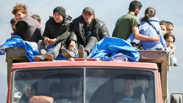 Refugees from Nagorno-Karabakh region ride in a truck upon their arrival at the border village of Kornidzor, Armenia. — courtesy Reuters