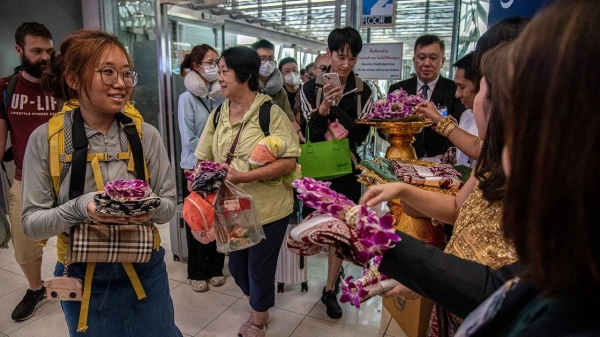 Chinese tourists are welcomed with souvenirs from Thai officials after arriving at Bangkok's Suvarnabhumi International Airport on September 25, 2023