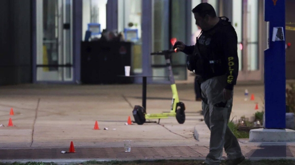 A police officer searches for evidence in front of a building at Morgan State University in Baltimore on Wednesday