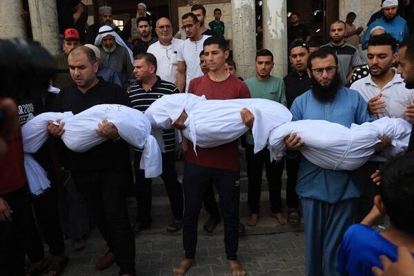 Relatives carry the bodies of children from the Abu Quta family who were killed in Israeli strikes on the Palestinian city of Rafah in the southern Gaza Strip.