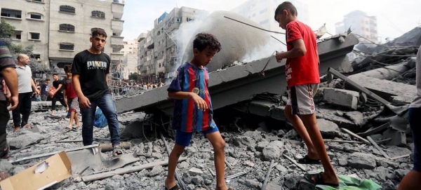 Children walk in the wreckage of homes destroyed by airstrikes in Al Shati refugee camp in the Gaza. — courtesy UNICEF/Mohammad Ajjour