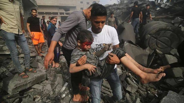 A Palestinian carries a child pulled out of a building hit in the Israeli bombardment of the Gaza Strip in Rafah, Sunday