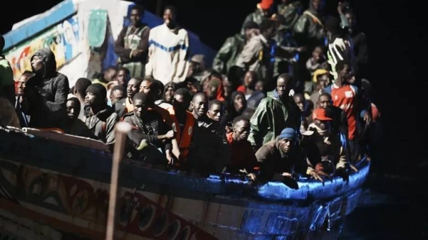 Migrants crowd a wooden boat as they are towed to the port in La Restinga on the Canary island of El Hierro on Saturday, Nov. 4, 2023
