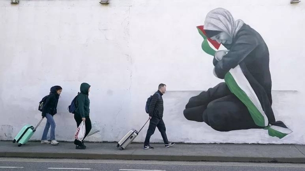 People walk past a pro-Palestinians mural by the artist Emmalene Blake in the Harold's Cross area of Dublin, Ireland