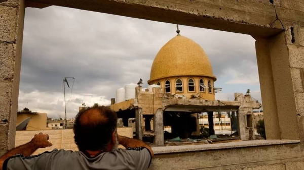 A Palestinian man looks at a mosque damaged in an Israeli air strike in Khan Younis, in the southern Gaza Strip. A BBC correspondent said the blackout would make it difficult to get information about what was happening in the war.