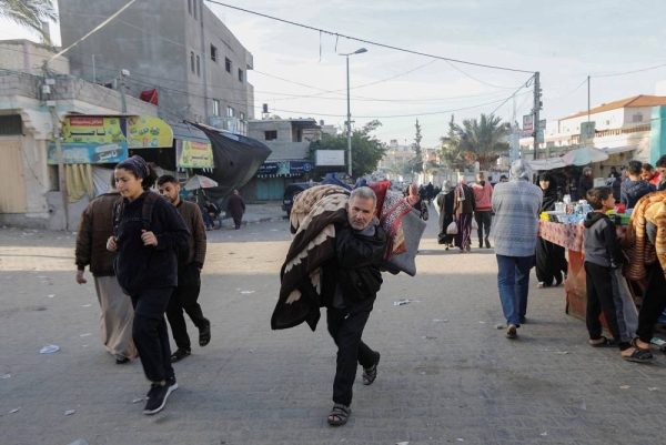 A displaced Palestinian man, who fled his house due to Israeli strikes, carries his belongings as he makes his way back to his home, during a temporary truce between Hamas and Israel, in Khan Younis in the southern Gaza Strip, Novemeber 24, 2023. REUTERS/Saleh Salem