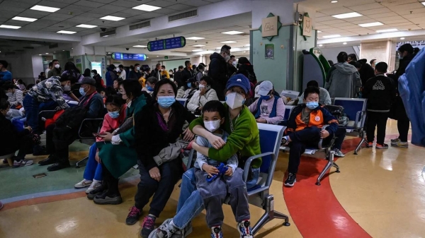 Children and their parents wait in a crowded outpatient hall at a children's hospital in Beijing on November 23, 2023