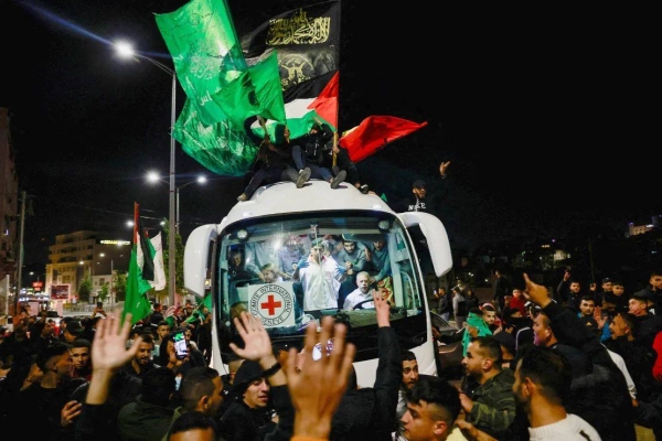 Released Palestinian prisoners react from inside a vehicle after leaving the Israeli military prison, Ofer, amid a hostages-prisoners swap deal between Hamas and Israel, near Ramallah in the Israeli-occupied West Bank, on Sunday