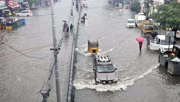 Commuters pass through a flooded road during heavy rains in Chennai as cyclone Michaung is expected to make landfall. —courtesy EPA