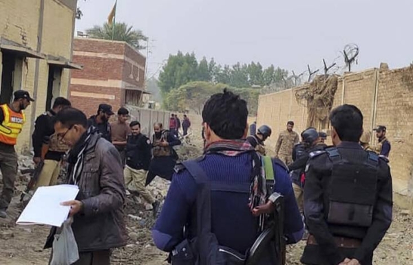 Security officials examine damage at the site of a bombing on the outskirts of Dera Ismail Khan, Pakistan on Tuesday