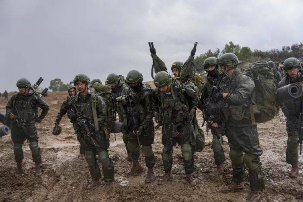 Israeli soldiers prepare to enter the Gaza Strip, at a staging area near the Israeli-Gaza border, in southern Israel, Wednesday,