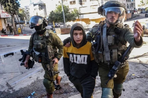 Israeli soldiers detain a young boy during demonstrations in Hebron, 2022. Israel has been accused of heavy-handed tactics