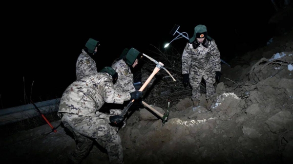 Rescuers dig through the debris of a house to search for survivors after an earthquake struck China's northwestern province of Gansu on December 18, 2023