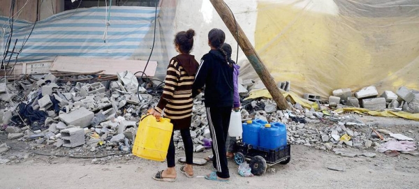 Children in Khan Younis stop to look at the destruction as they go in search for water. — courtesy UNICEF/Eyad El Baba