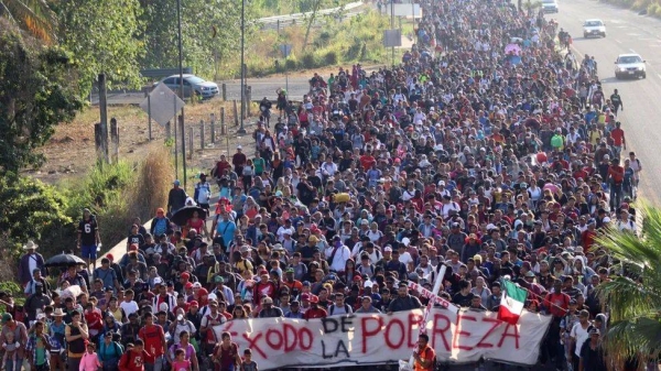 The Christmas Eve caravan is walking under a banner saying Poverty Exodus in Spanish