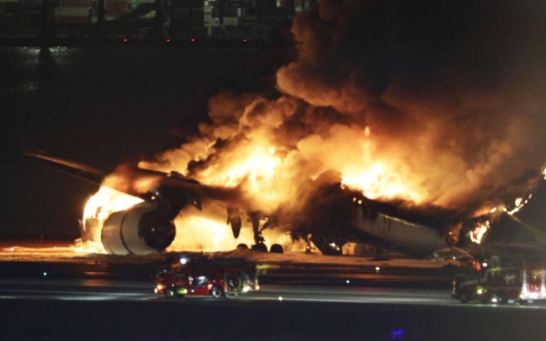 Photo shows a Japan Airlines airplane engulfed in flames on a runway at Tokyo's Haneda airport. (Credit: Kyodo)