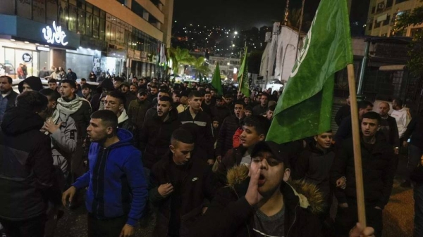 Palestinian demonstrators wave Hamas flags and shout slogans during a protest following the killing of top Hamas official Saleh Arouri in Beirut, in the West Bank