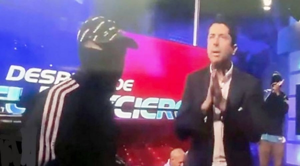 Armed men interrupt live broadcast and threaten presenter.