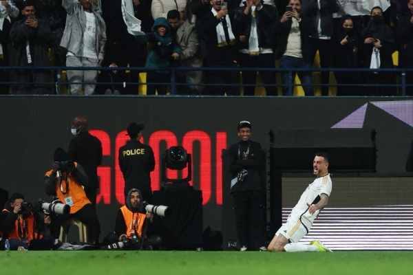 Joselu celebrates the crucial goal with a knee slide in front of an enthusiastic crowd at Al Awwal Park.