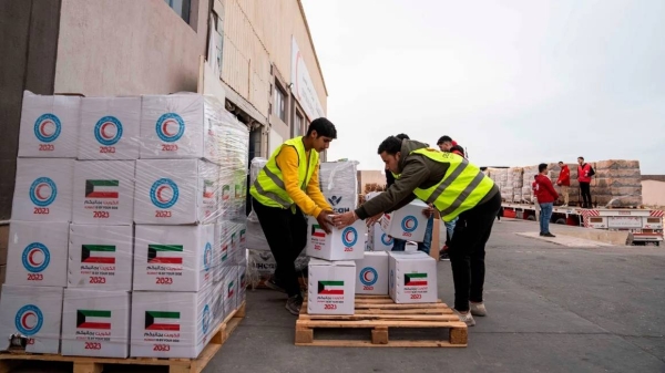 Members of the Egyptian Red Crescent and civil organizations work to mobilize aid in the Egyptian Red Crescent warehouse in preparation for its entry into the Gaza Strip