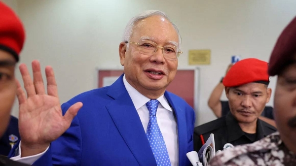 Najib Razak is escorted by security personnel at a court in Kuala Lumpur on January 19