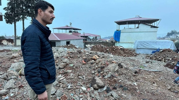 Sezai Karabas stands on the rubble of his former home in Islahiye, Gaziantep province, southern Turkey